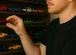 Um colecionador organizando suas miniaturas de carros em uma prateleira de exposição, demonstrando como evitar erros comuns de colecionismo.