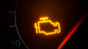 Painel de carro com a luz de injeção eletrônica acesa (símbolo de motor amarelo), indicando a necessidade urgente de diagnóstico para evitar danos ao motor ou catalisador.