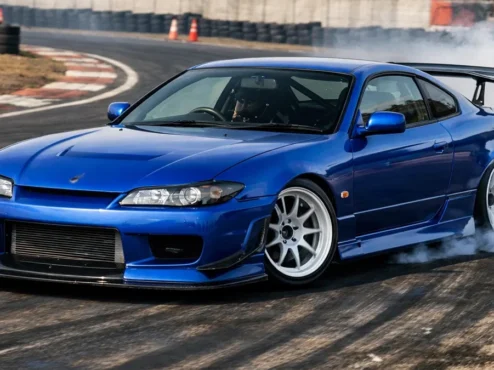 Nissan Silvia S15 azul Spec-R preparado para drift em uma pista, destacando o design icônico e as rodas esportivas.