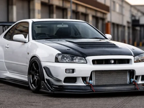 Nissan Skyline com modificações aerodinâmicas funcionais mostrando splitter de carbono e intercooler exposto.