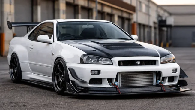 Nissan Skyline com modificações aerodinâmicas funcionais mostrando splitter de carbono e intercooler exposto.