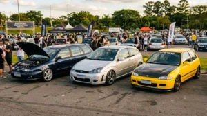 carros icônicos como Fiat Marea, Ford Focus MK1 e Honda Civic VTi em um encontro de entusiastas.