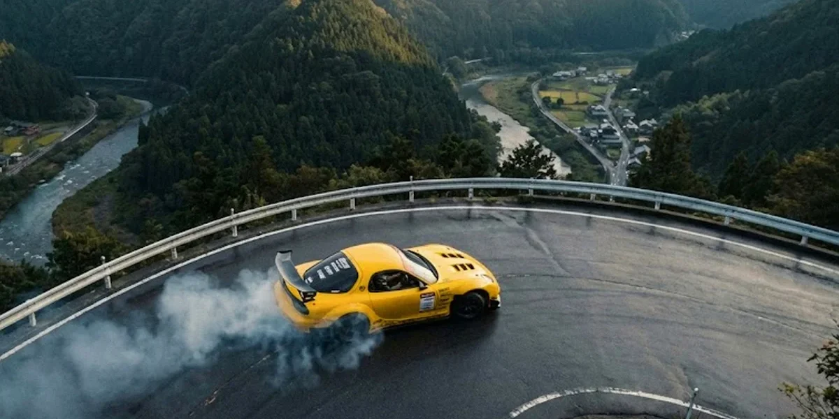 mazda-rx7-montanha-tracao-traseira Mazda RX7 amarelo executando um drift perfeito em estrada sinuosa