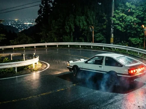 Toyota AE86 branco fazendo drift em uma estrada sinuosa nas montanhas do Japão durante a noite.
