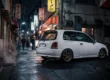Toyota Starlet Glanza V branco rebaixado com rodas de liga leve em um cenário urbano japonês à noite.