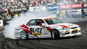 Ken Nomura pilotando o Nissan Skyline ER34 da Blitz em um ângulo extremo de drift durante o D1 Grand Prix.