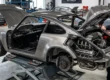 Um Porsche 911 clássico em processo de restomod, exibindo motor moderno e acabamento em fibra de carbono.