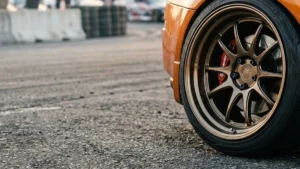 Close-up de uma roda esportiva com borda profunda apresentando estilo poke, saindo levemente da linha do para-lama do carro.