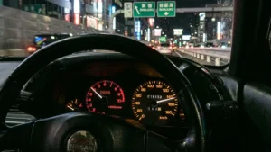 Close-up de um velocímetro de um Nissan Skyline R32 marcando o limite máximo de 180 km/h em um painel JDM.