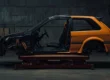 Carro esportivo parcialmente desmontado em um elevador de oficina, representando o início de um projeto de track day vindo de leilão.