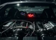 Interior de carro com foco na luz de óleo vermelha acesa no painel, indicando perigo imediato no motor.