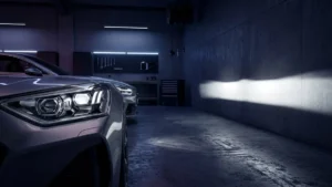 Farol esportivo automotivo com lente projetora exibindo uma linha de corte de luz perfeita contra uma parede escura.