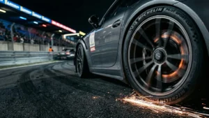 Detalhe de pneu esportivo em alta velocidade em pista de corrida à noite, evidenciando o estresse térmico do composto de borracha.