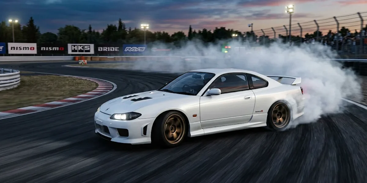 Nissan Silvia S15 branco fazendo drift em uma pista de corrida durante o entardecer, com fumaça saindo dos pneus traseiros.