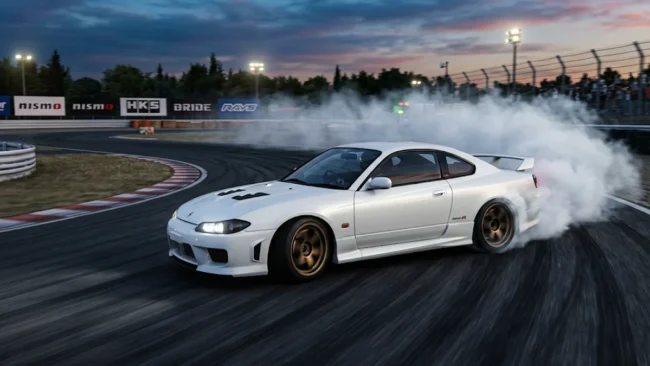 nissan-silvia-s15-spec-r-drift-pista Nissan Silvia S15 branco fazendo drift em uma pista de corrida durante o entardecer, com fumaça saindo dos pneus traseiros.