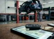 Chave de carro sobre smartphone exibindo documento digital CRLV em cima de uma mesa de escritório com fundo automotivo.