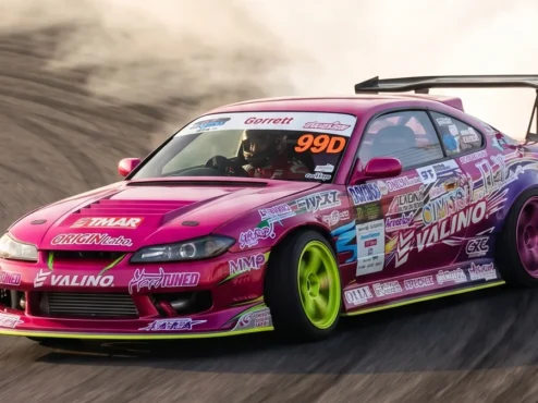 Nissan Silvia S15 rosa e roxo de Naoki Nakamura fazendo drift no D1GP com extrema fumaça e agressividade.