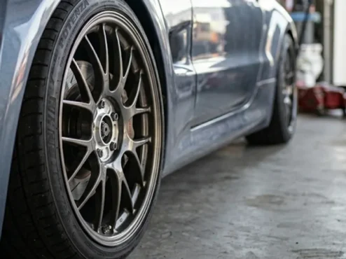 carro-esportivo-fitment-espacador-roda Roda esportiva montada rente ao para-lama de um carro, destacando o fitment agressivo proporcionado pelo uso de espaçadores.