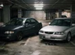 Fotografia de um Mazda Protegé e um Mazda 626 dos anos 90 estacionados em uma garagem subterrânea com modificações sutis estilo JDM.