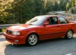Nissan Sentra SE-R B13 vermelho em movimento em uma estrada sinuosa ao entardecer.