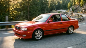 Nissan Sentra SE-R B13 vermelho em movimento em uma estrada sinuosa ao entardecer.
